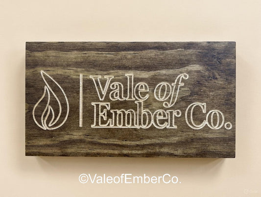 Wooden sign with 'Vale of Ember Co.' branding on a beige background