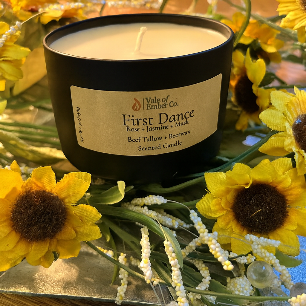 Vale of Ember Co. First Dance beef tallow and beeswax candle surrounded by sunflowers