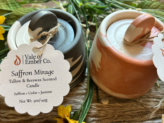 Two marbled colored concrete candles with decorative tags says "Vale of Ember Co" on a natural background